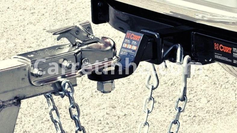 Corrente de segurança conectada ao engate de um veículo e à estrutura de uma carretinha.