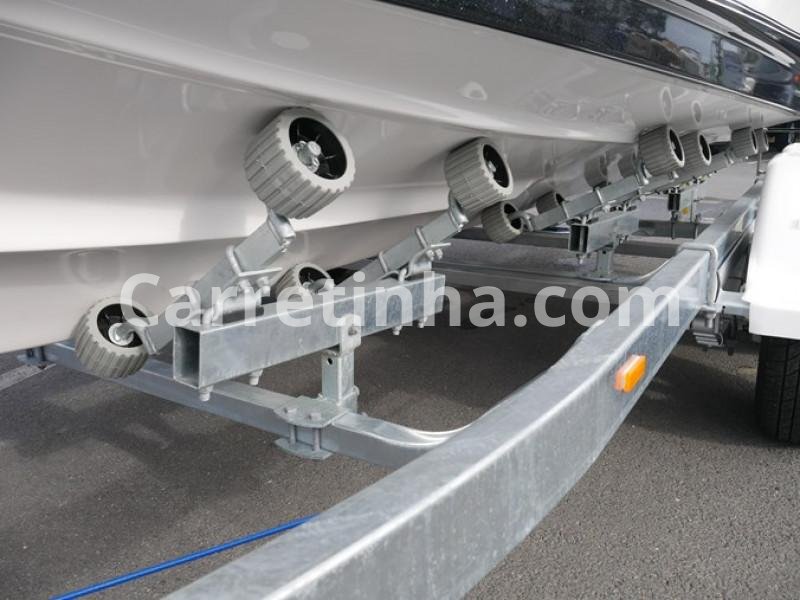 Lancha apoiada em um reboque náutico com estrutura metálica e suportes posicionados para acompanhar o formato do casco, demonstrando a importância do encaixe correto durante o transporte.