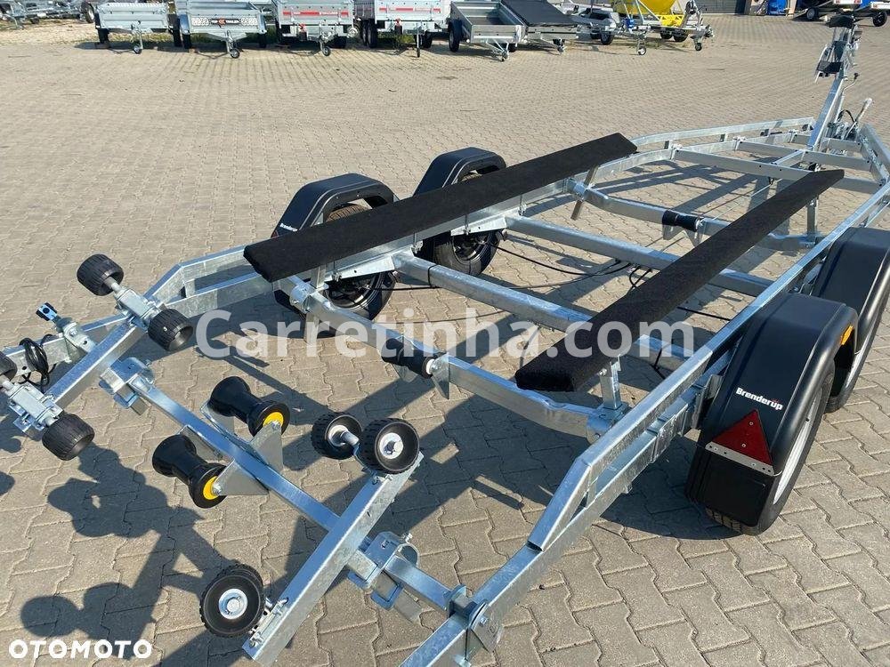 Componentes de apoio de uma carreta náutica, incluindo travessa revestida com carpete e roletes poliméricos, utilizados conforme o desenho do casco e o projeto do reboque.