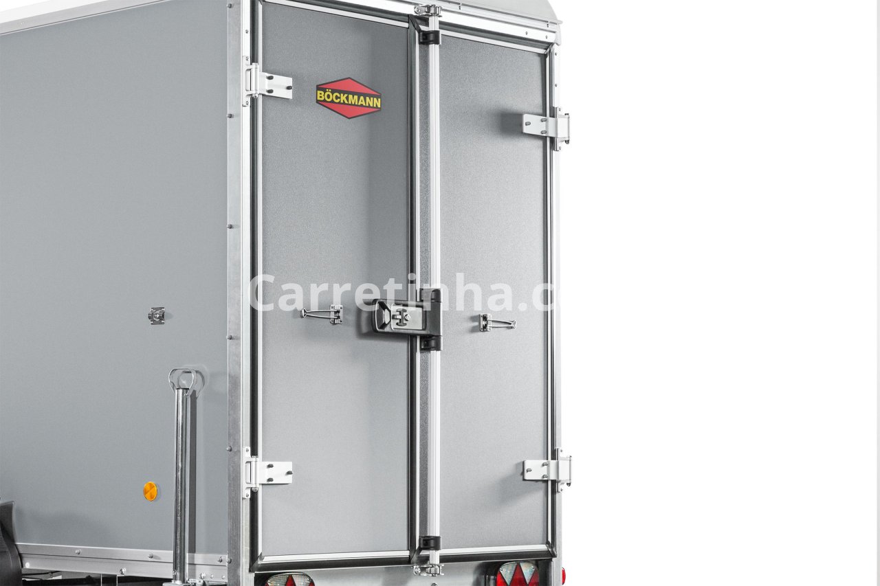 Detalhe das portas traseiras de um reboque fechado com ferragens metálicas e sistema de travamento para restringir o acesso à carga.