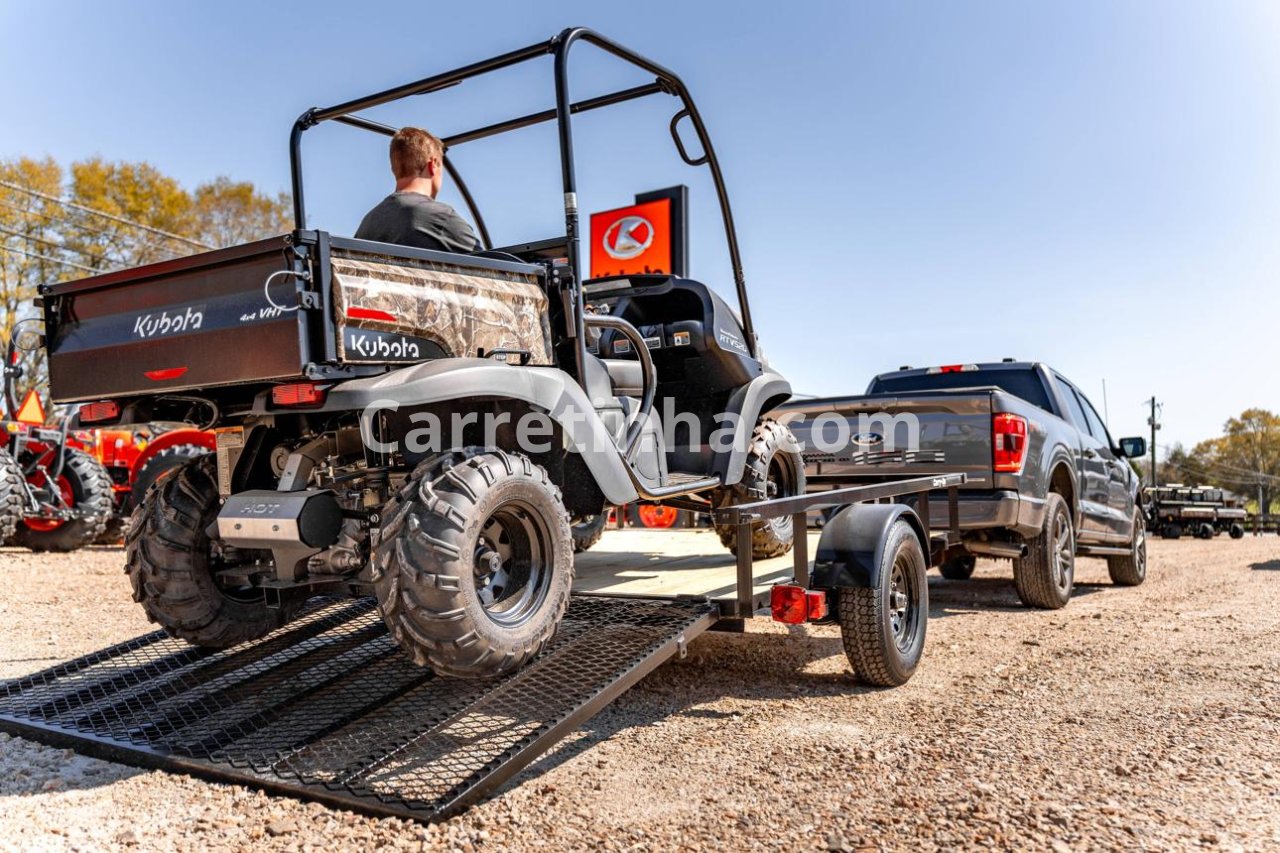 Quadriciclo posicionado sobre uma carretinha prancha e preparado para transporte, ilustrando uma necessidade comum de proprietários de veículos off-road.
