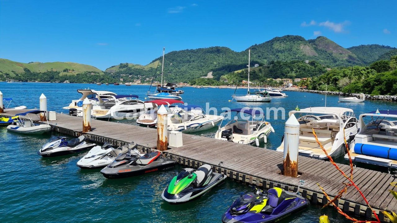 Vista de uma marina com embarcações organizadas em píeres, ilustrando a infraestrutura usada para guardar barcos e facilitar o acesso à navegação.
