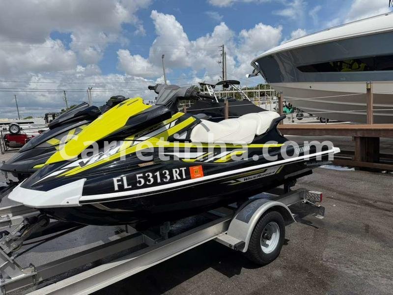Moto aquática usada sobre um reboque náutico, em uma marina, pronta para ser fotografada e anunciada para potenciais compradores.