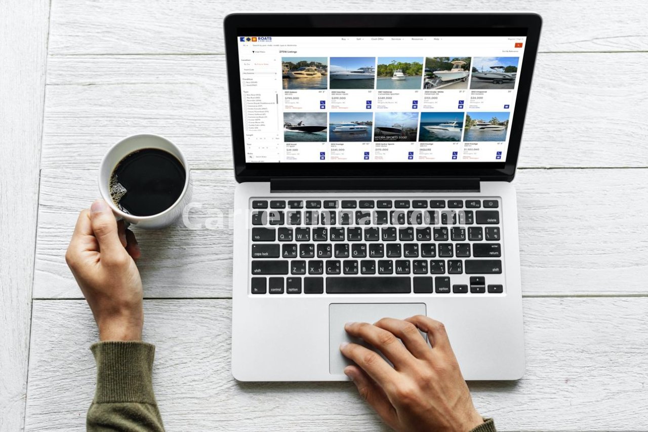 Potencial comprador consultando anúncios de barcos e lanchas em um computador enquanto avalia opções disponíveis no mercado.