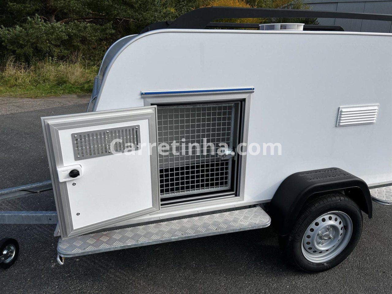 Carretinha fechada desenvolvida para transporte animal, com aberturas de ventilação e compartimento protegido.
