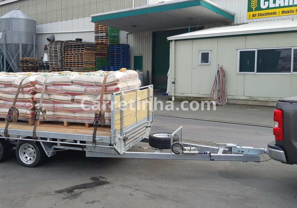 Reboque aberto utilizado para transportar rações ensacadas e produtos agrícolas em uma operação comercial.